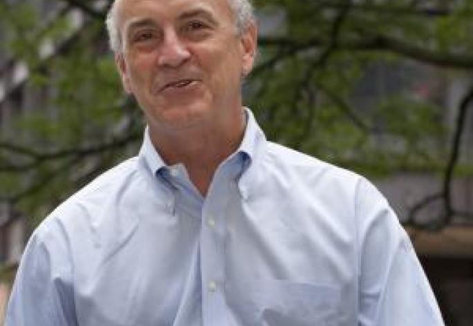 color photo of man in dress shirt smiling